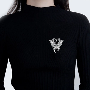 Broche nœud élégante en argent avec cristaux de zircon sur un pull en maille noire
