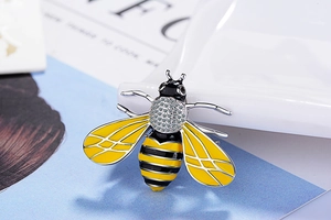 Detailed view of bee brooch featuring pavé crystals and vibrant enamel wings