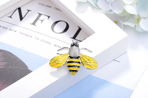 Macro detail of bee brooch with yellow enamel wings and sparkling crystal rhinestones