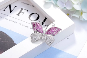 Macro detail of butterfly brooch showing gradient pink and white zircon pavé setting