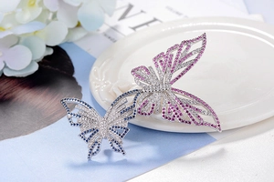 Detailaufnahme der Schmetterlingsbrosche mit Pavé-Diamanten und rosa und blauen Edelsteinen