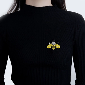 Fashion bee brooch with yellow enamel and crystals worn on a black knit sweater