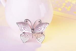 Detail of silver butterfly brooch featuring pink zircons and delicate pin backing