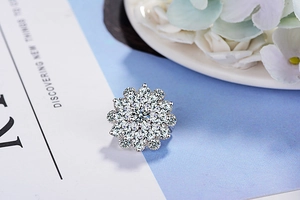 Macro view of a silver floral brooch with intricate cubic zirconia pavé detailing