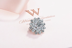 Macro shot of silver floral ring with cubic zirconia on a romantic wedding invitation