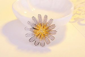 Detail einer Gänseblümchen-Brosche mit Zirkon-Blütenblättern und goldenem Staubblatt