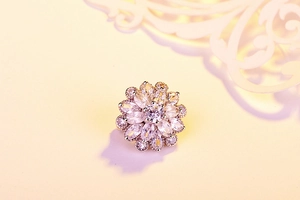 Macro view of floral brooch with marquise-cut zircon crystals and silver metal setting