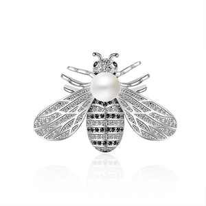 Fashion bee brooch with sparkling crystals and large white pearl on a white background