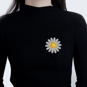 Eleganter Gänseblümchen-Broschenstift mit Zirkon-Kristallen auf schwarzem Strickpullover