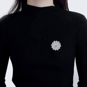 Sparkling silver flower brooch with cubic zirconia crystals on a black knit sweater