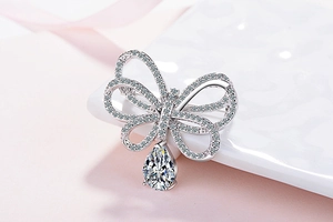 Vue macro d'une broche noeud en argent avec zircons et pierre tombante en forme de poire