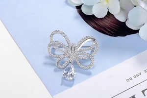Détail d'une broche papillon avec zircons micro-paves et pierre suspendue en forme de poire
