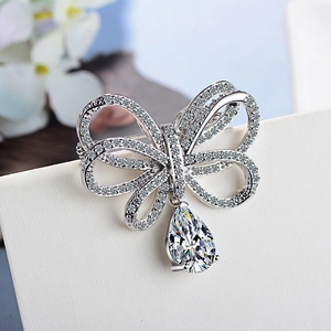 Broche nœud argentée étincelante avec micro-pavage de zircons et élégant pendentif en poire