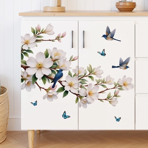 Floral wall decal with white magnolias and blue birds on a white storage cabinet