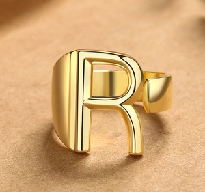 Detailopname van de gouden verstelbare letter R ring met een gepolijste spiegelafwerking