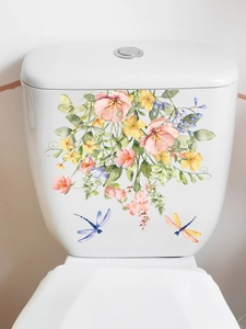 Detail of floral and dragonfly wall stickers on a clean white bathroom toilet tank