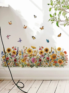 Détail de stickers muraux floraux avec tournesols et papillons sur plinthe blanche