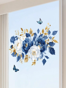 Close-up of blue and white flower wall stickers with gold leaves and butterflies on a window