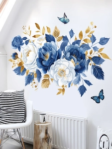 Detailed view of blue flower wall stickers with golden leaves on a clean white wall