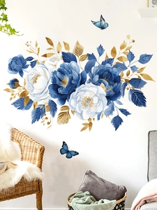 Detail of blue floral wall decals with golden leaves and butterfly on a white wall