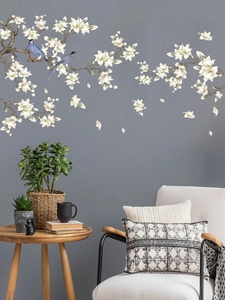 Detail of elegant white magnolia wall decals with blue birds and falling petals