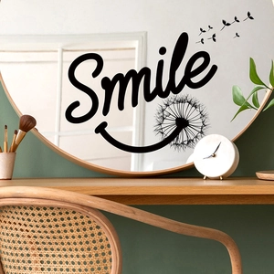 Close-up of black Smile text and dandelion wall sticker on a round decorative mirror