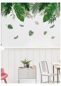 Détail de stickers muraux feuilles tropicales et papillons bleus dans un salon