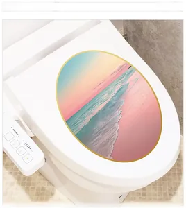 Detail view of oval toilet lid sticker featuring a sunset beach landscape with golden edges