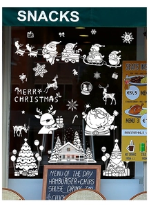 Detail von weißen Weihnachts-Fensteraufklebern mit Weihnachtsmann und Rentier am Schaufenster