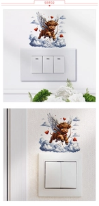 Detail view of Highland Cow switch sticker with cupid elements and blue cloud on wall
