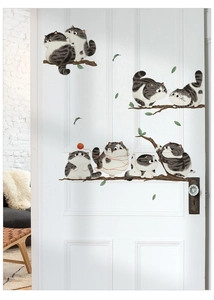 Detailed view of cute cartoon cats on tree branches wall stickers applied to a white door