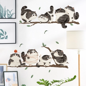 Cartoon cat wall decals featuring cute cats playing with yarn on a white wall