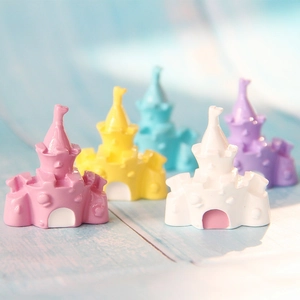 Close-up of mini resin castle figurines in pastel colors for DIY crafts and micro landscapes