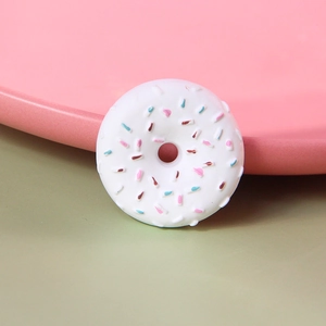 Macro view of a white resin doughnut charm with colorful sprinkles for DIY crafting