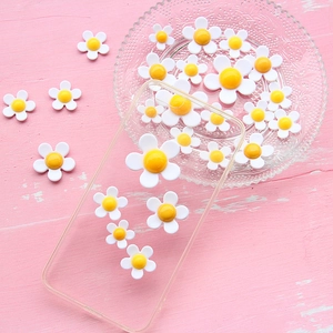 DIY acrylic daisy flower charms kit for phone case decoration on pink wooden surface