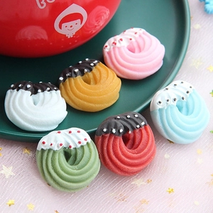 Close-up of miniature resin Christmas donuts with spiral texture and colorful cream topping
