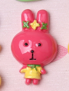 Detailed view of pink resin bunny DIY accessory with yellow dress for hair clips