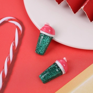 Close-up of DIY resin mini pink coffee cups with green glitter for Christmas crafts