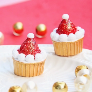 Miniatura di cupcake natalizio con cappello di Babbo Natale rosso e base dorata