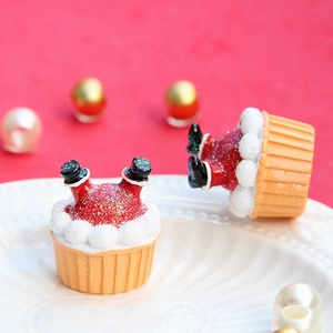 Dettaglio di ciondoli natalizi in resina con stivali di Babbo Natale e glitter rossi