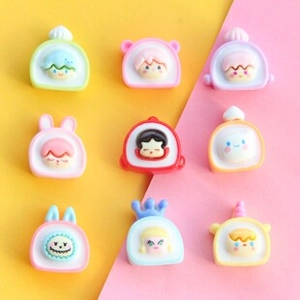 Detail of 9 assorted cartoon resin cake roll charms for DIY crafts and accessories