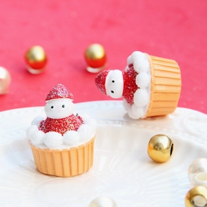 Dettaglio macro di mini ciondoli cupcake natalizi con decorazioni a fragola glitterata