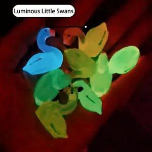 Luminous resin little swan figurines in multiple colors glowing in the dark in hand