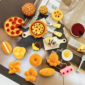 Flat lay macro of detailed resin miniature food models including burgers, pizza, and cakes
