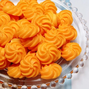 Detailed macro view of orange spiral resin cookie charms on a decorative glass tray