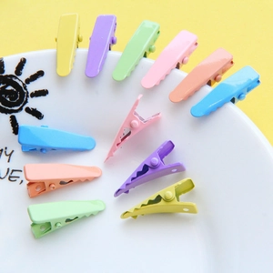 Set of colorful macaron candy hair clips on a decorative ceramic plate with bright background