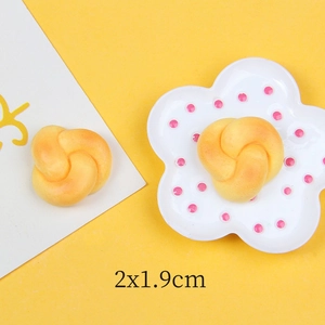 Macro detail of miniature resin bread twist model with golden texture and 2x1.9cm dimensions