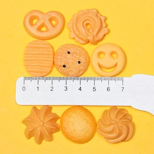 Flat lay of miniature resin snacks like cookies and biscuits with a ruler for scale