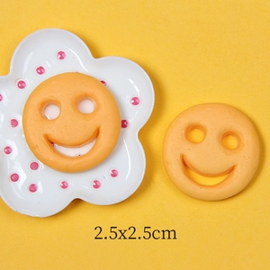 Detailed macro view of 2.5cm yellow resin smiley face charms for DIY accessory crafts