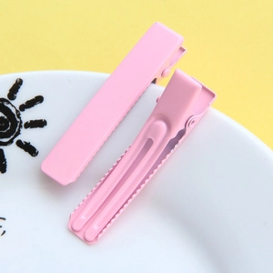 Close-up of pink matte metal duckbill hair clips with non-slip serrated edge design